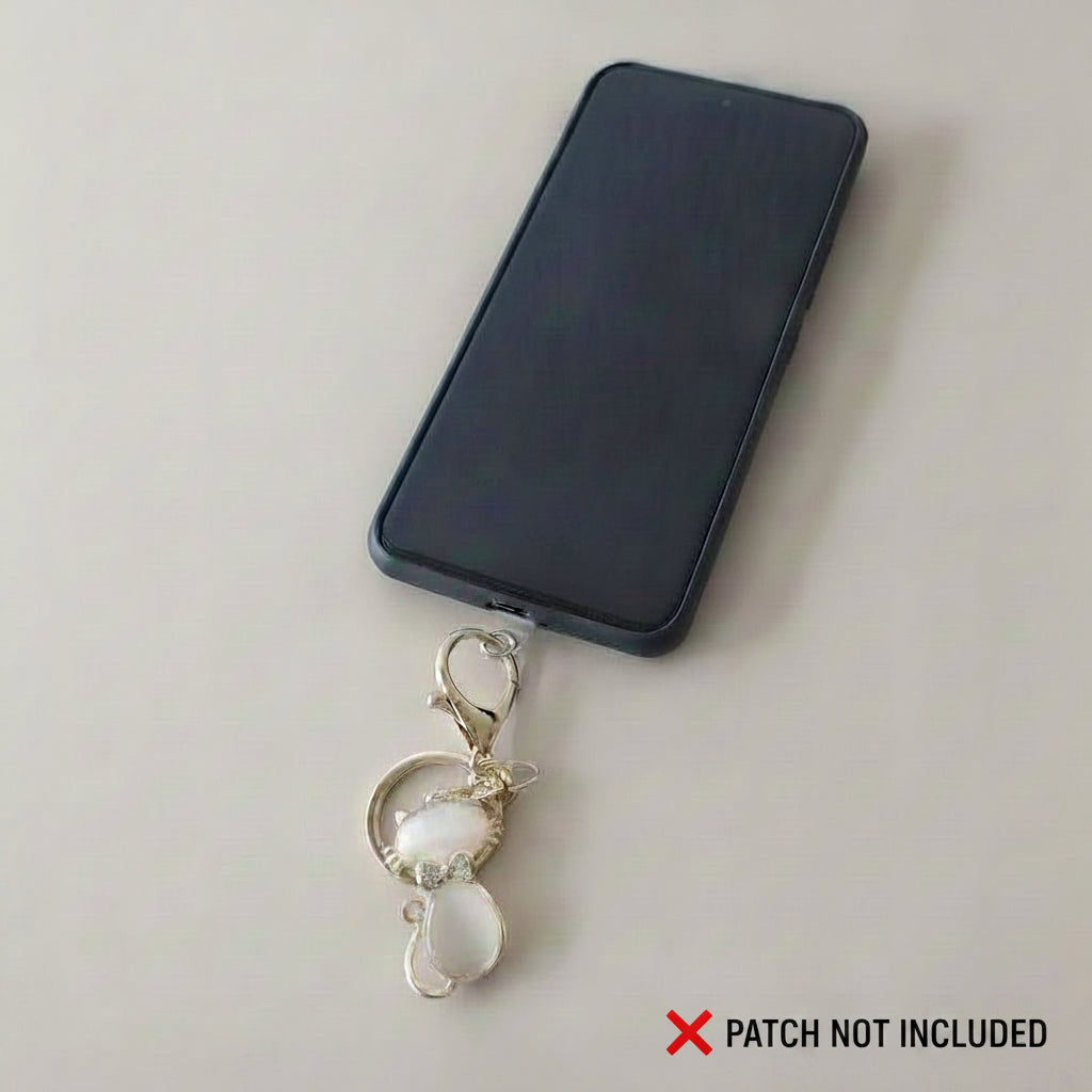 Bijou Félin Poudré One2K utilisé comme bijou de téléphone accroché à une coque noire via mousqueton doré – patch non inclus