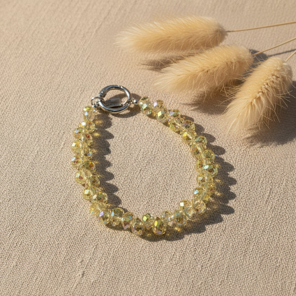 Bijou 2-en-1 Dragonne de Poignet & Bijou de Sac Éclat Boréal reflets solaires One2K – vue présentation sur fond lin avec herbes de pampa, bracelet dragonne en perles de cristal facettées aux reflets dorés et irisés solaires, fermoir anneau argenté